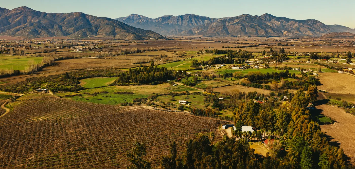 Vista del valle de Rapel con campos, casas y cordillera